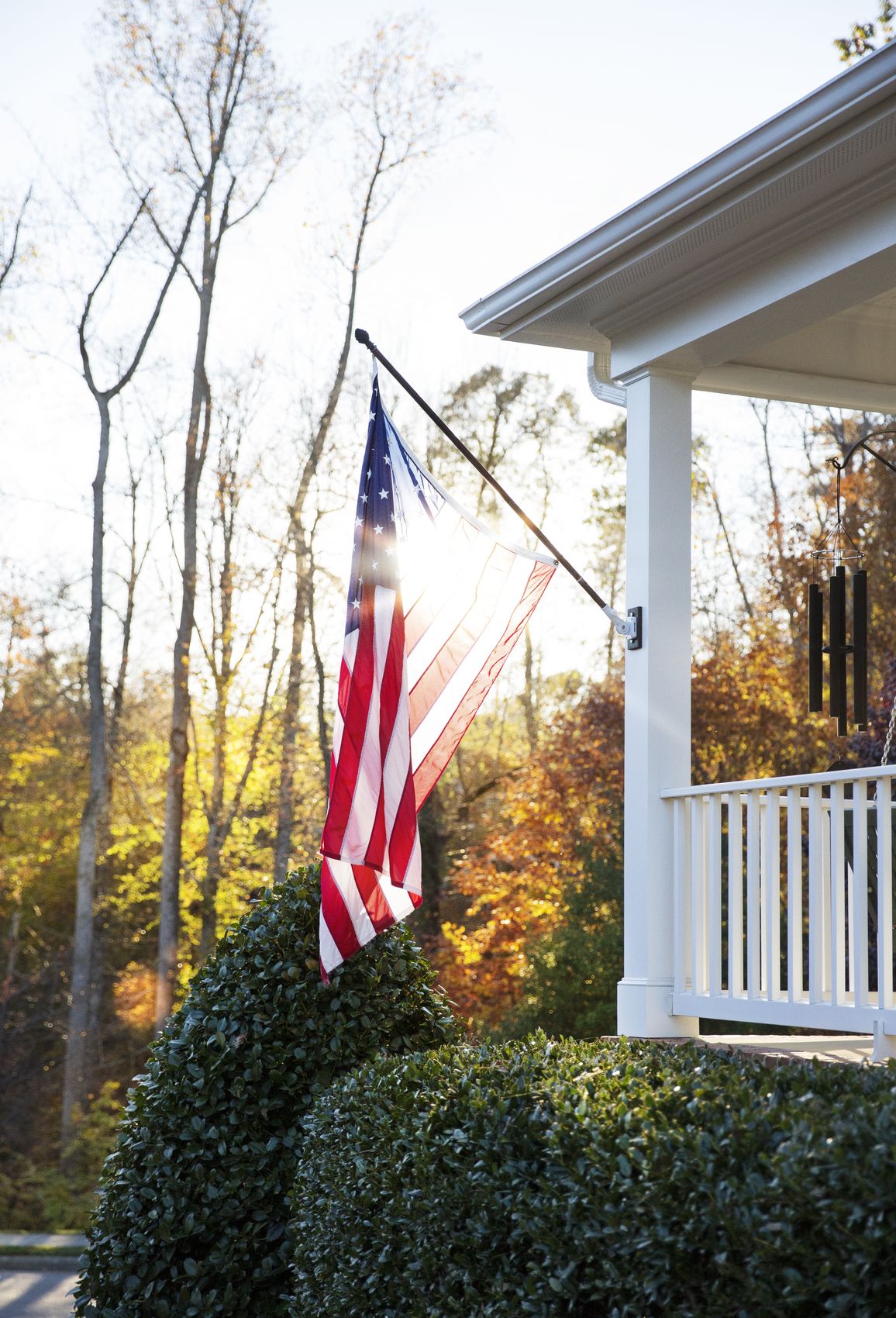 Front porch with an American flag at sunset in autumn